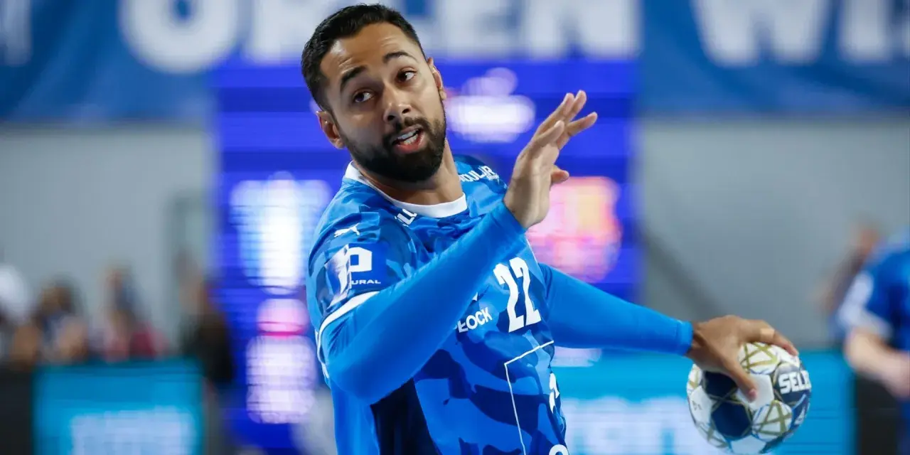 Gracz gog handball w niebieskiej koszulce z numerem 22, gotowy do rzutu.