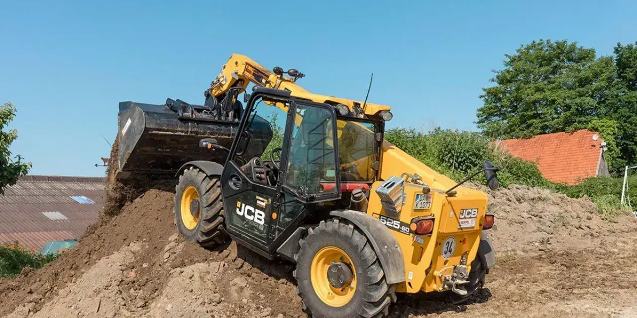 Żółty ładowarka teleskopowa JCB 525-60 z podniesionym wysięgnikiem i łyżką, pracująca na budowie.