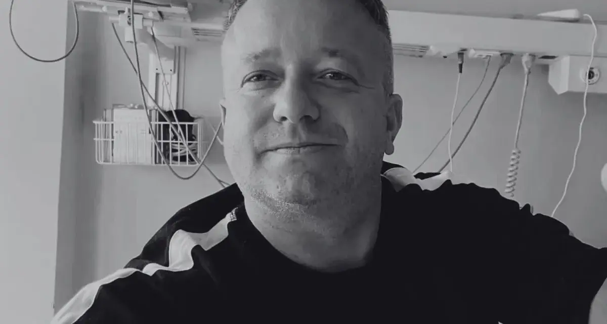 Uśmiechnięty mężczyzna w szpitalnym łóżku, słuchający dj hazel utwory.
