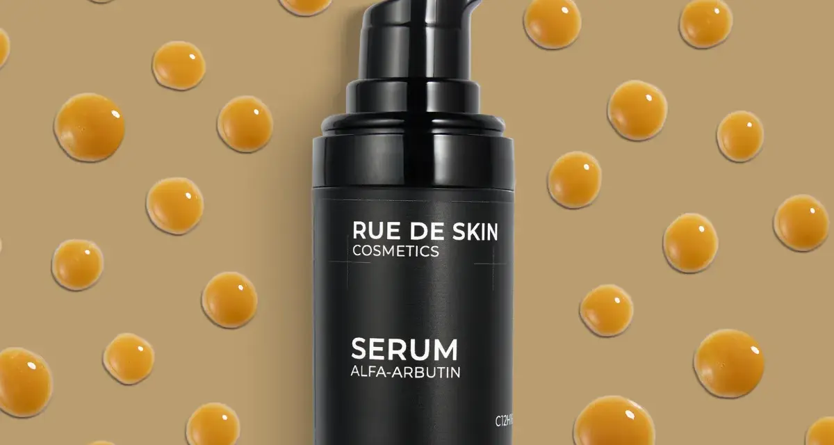 Czarny flakonik serum z alfa-arbutyną, otoczony kropelkami o bursztynowym kolorze.