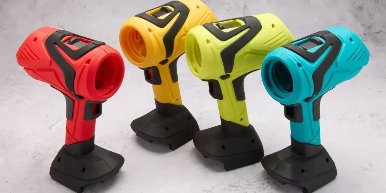 Spools of colorful 3D printing filament and containers of material on a wooden surface.