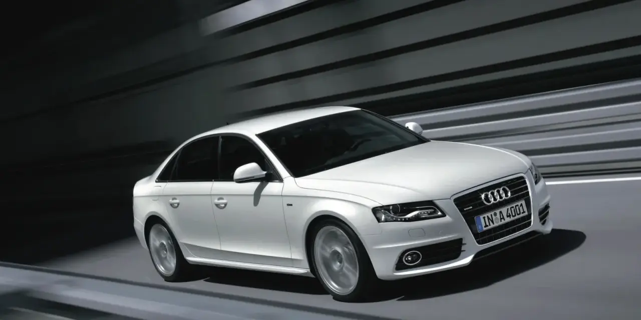 Białe Audi A4 B8 w ruchu, z rozmytym tłem. Wiele osób szuka audi a4 b8 opinie, by poznać jego zalety.