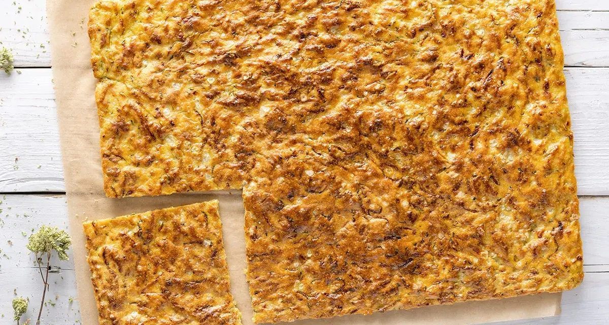 Una dorata schiacciata di zucchine, croccante fuori e morbida dentro, pronta per essere gustata.