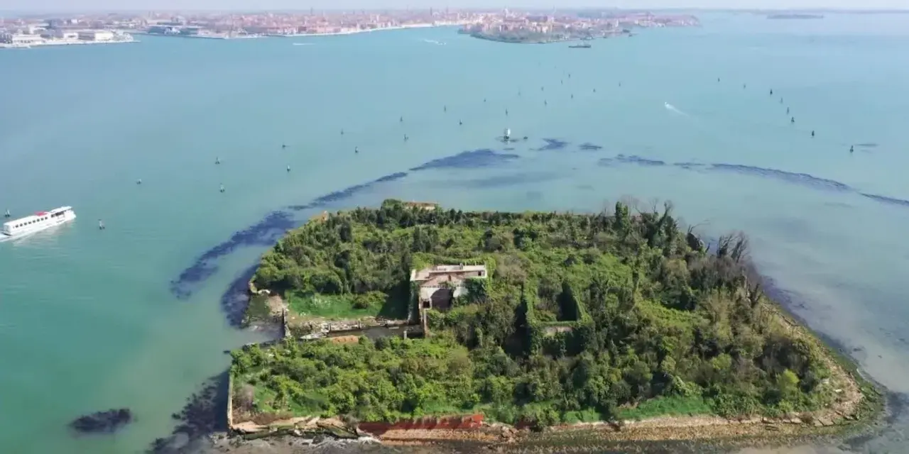 Un'isola verdeggiante con ruderi antichi, circondata da acque azzurre. Venezia è un'isola, e questa vista aerea ne mostra la bellezza selvaggia.