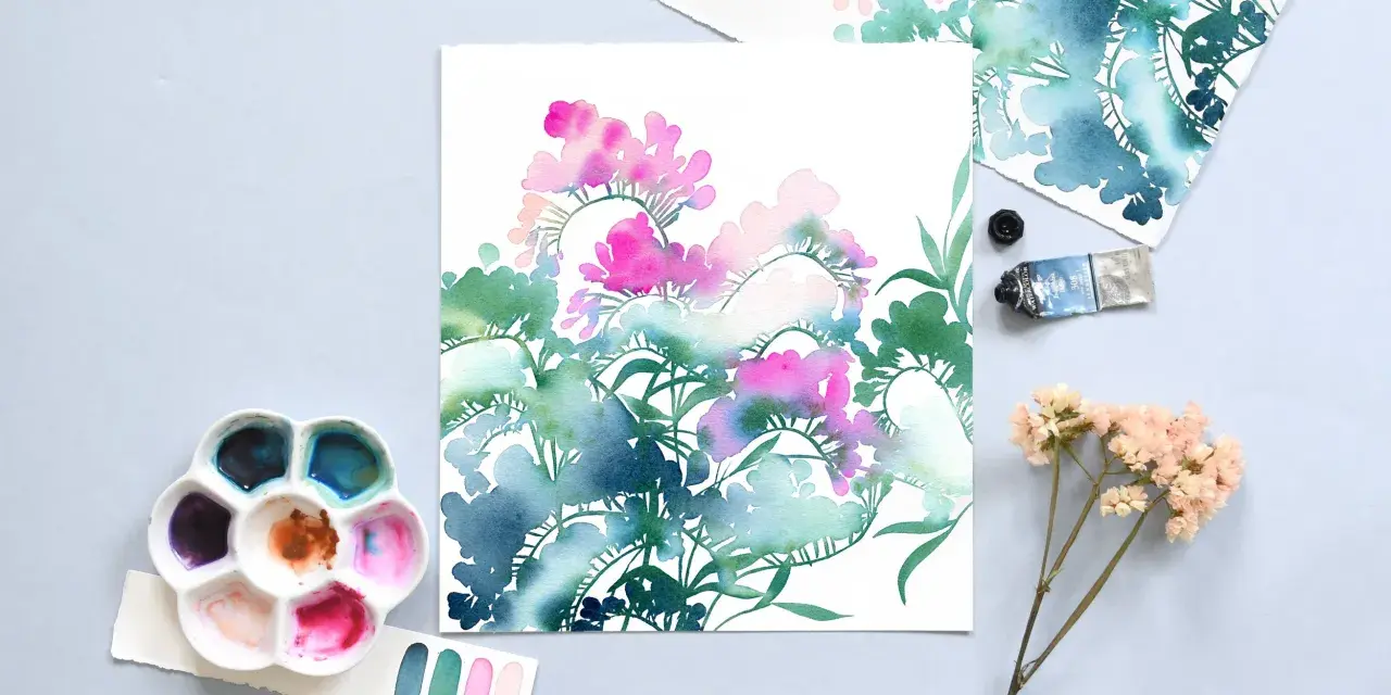 Palette d'aquarelle et tube de peinture prêts à peindre fleur. Des touches de rose et de bleu sur papier blanc.
