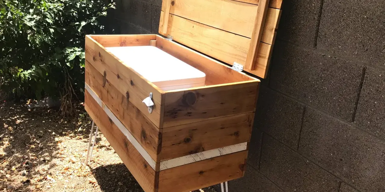 Wooden DIY deck box with lid open, showing white interior, on hairpin legs.