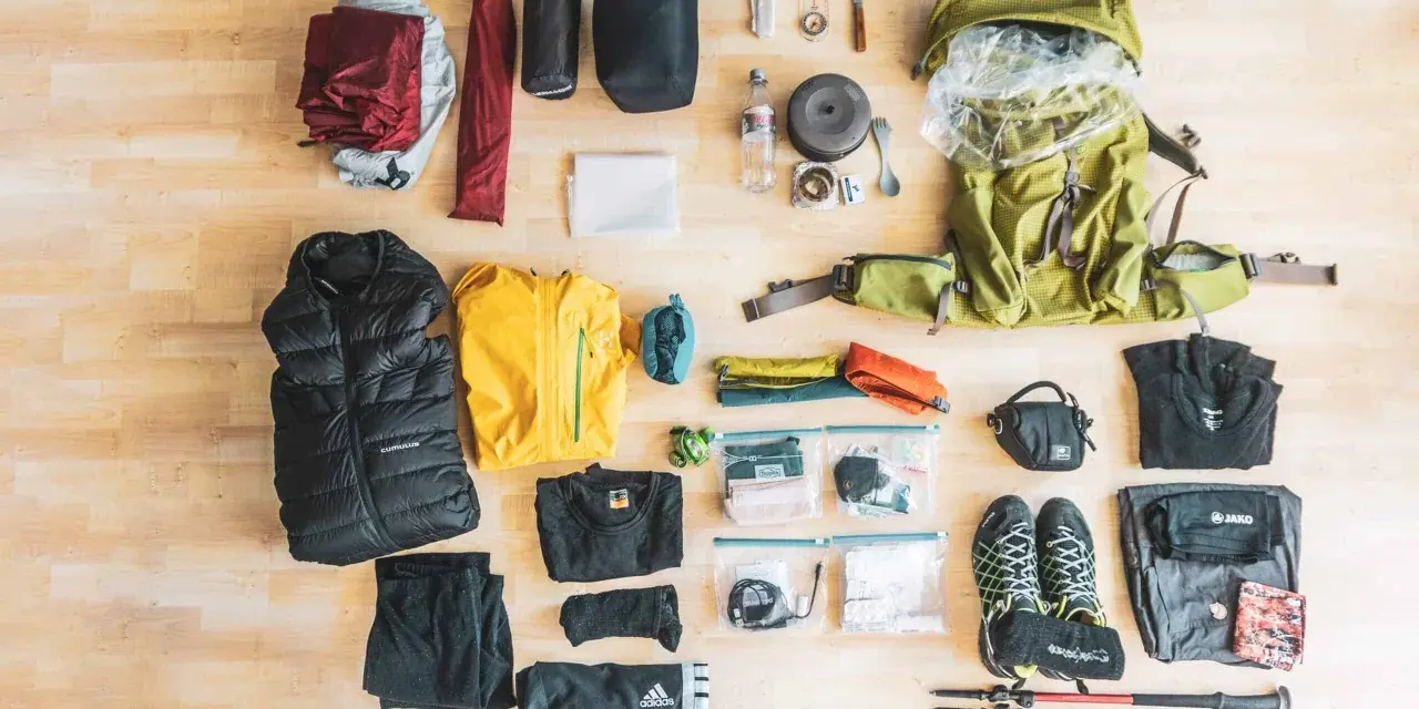 Rucksack, Zelt, Schlafsack, Jacken, Schuhe, Wanderstöcke und weitere Ausrüstung für eine perfekte backpacking packliste.