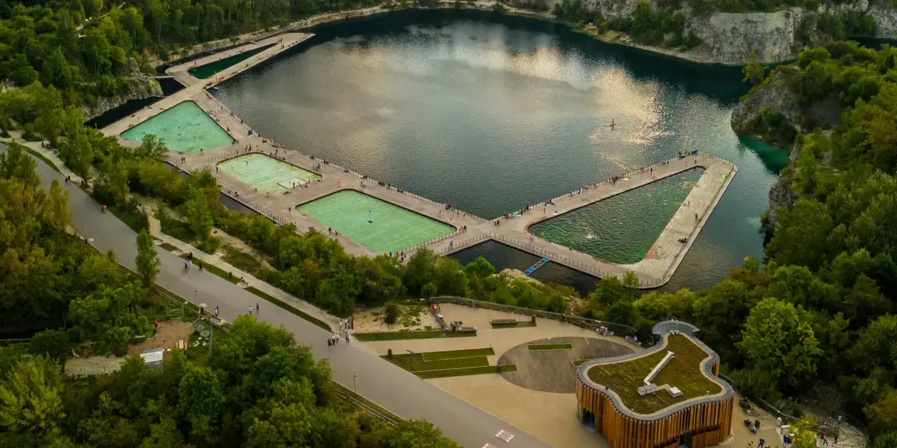 Kraków skałki: nowoczesne baseny w kamieniołomie, otoczone zielenią i skalnymi ścianami.