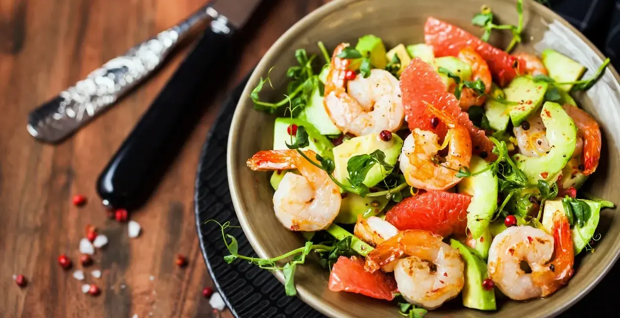 Salade avocat crevette fraîche et colorée, garnie de pamplemousse et de pousses vertes. Un délice léger.
