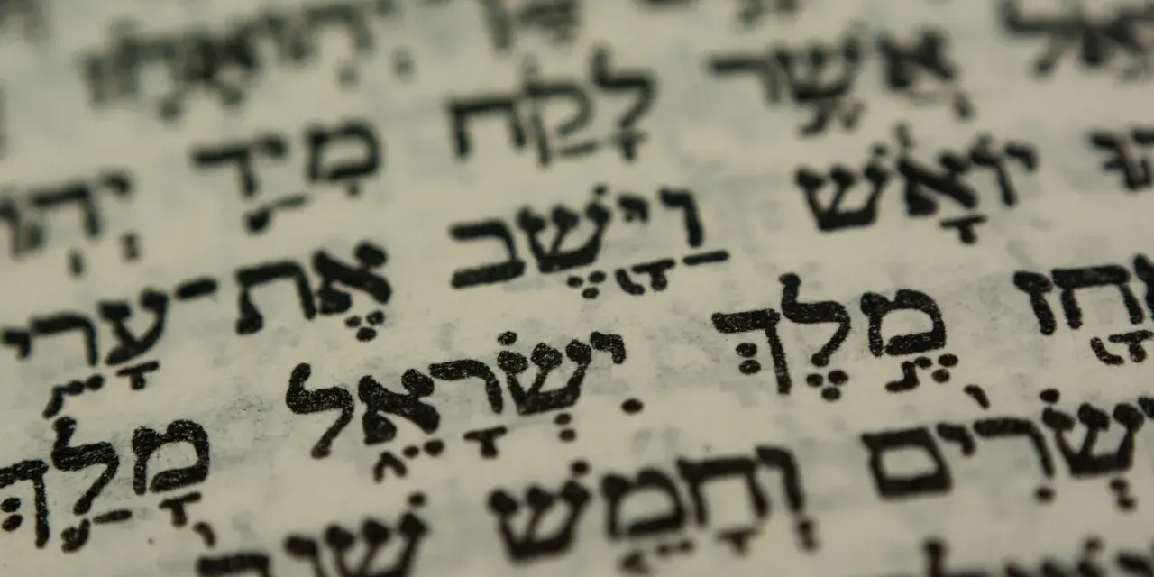 Close-up of Hebrew text on aged paper, hinting at the biblical meaning of Israel through ancient scripture.