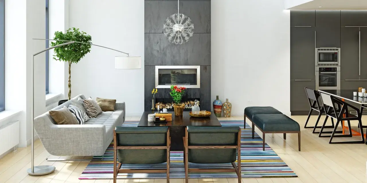 Nowoczesne wnętrza: szara sofa, kominek, designerskie krzesła i kuchnia. Różnorodne style wnętrz w jednym, przestronnym salonie.