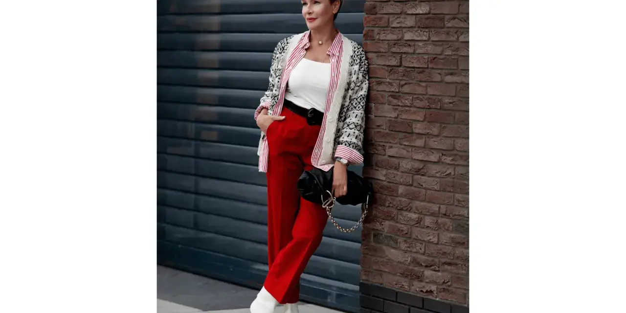 Elegancka kobieta w czerwonych spodniach i wzorzystej marynarce, prezentująca modne stylizacje.