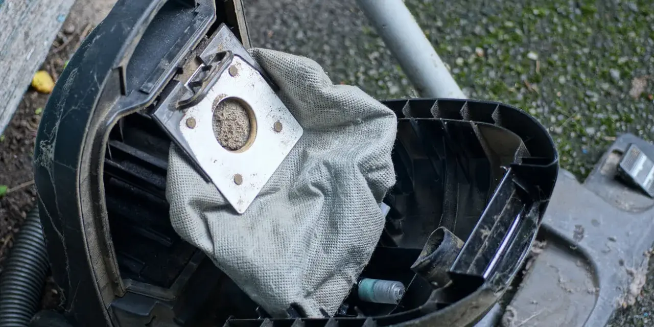 Ein staubsauger beutel wechseln ist nötig. Der alte, volle Beutel liegt offen, bereit für den Austausch.