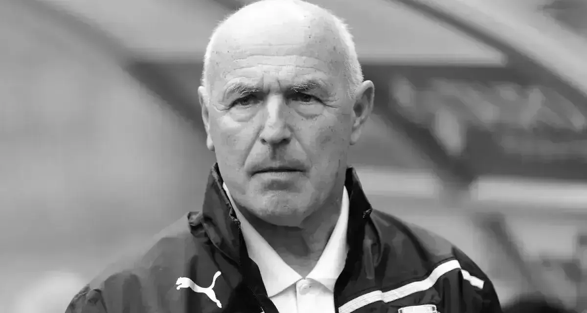 Portret siwowłosego mężczyzny, lenczyk trener piłkarski, w kurtce sportowej z logo Puma.
