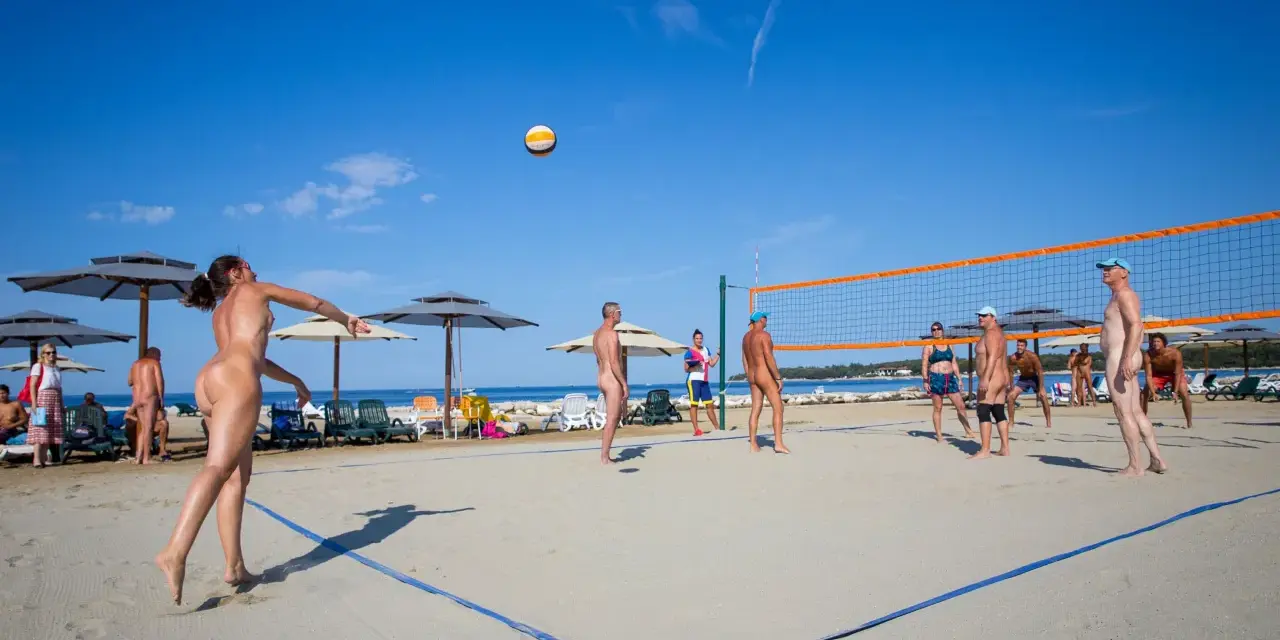 Gra w siatkówkę na plaży w Valalta naturist camp. Słońce, piasek i sportowa rywalizacja w wolności.
