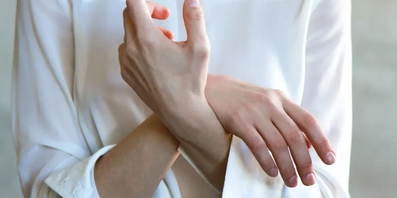 En person håller sin handled, möjligen på grund av inflammation i senskidan.