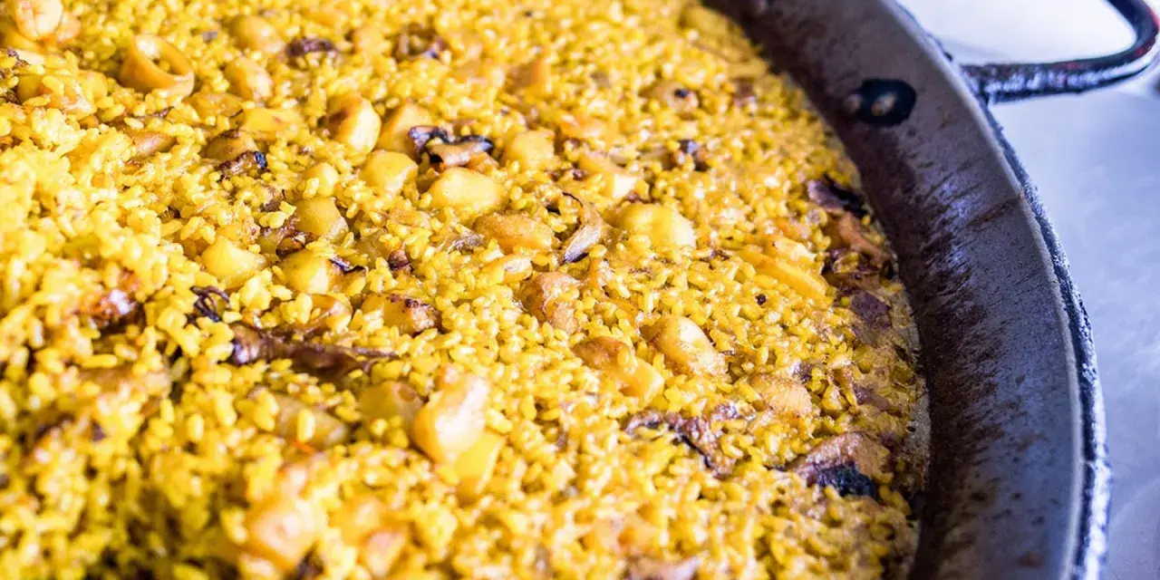 Arroz a banda recién hecho, con trozos de patata y marisco, listo para disfrutar.