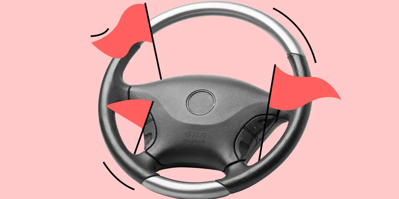 Lenkrad mit roten Flaggen, die auf einen hohen Kilometerstand des Autos hinweisen.