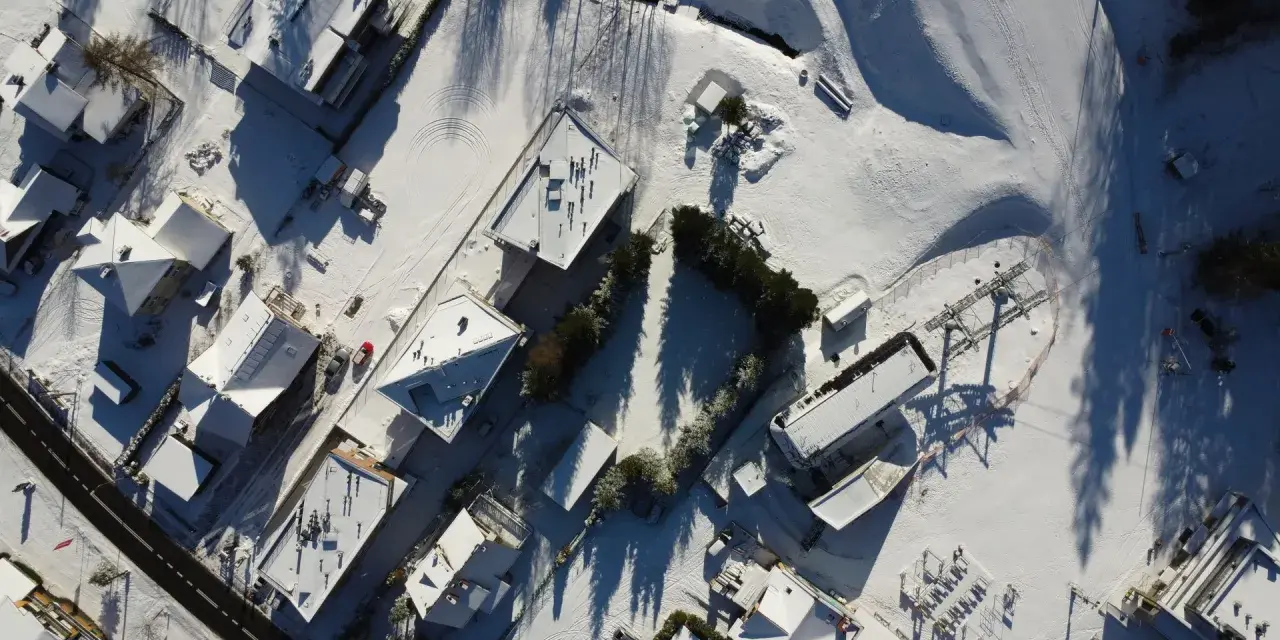 Śnieg pokrywa dachy domów i stoki. Idealne miejsce na ferie zimowe 2026 w województwie śląskim.