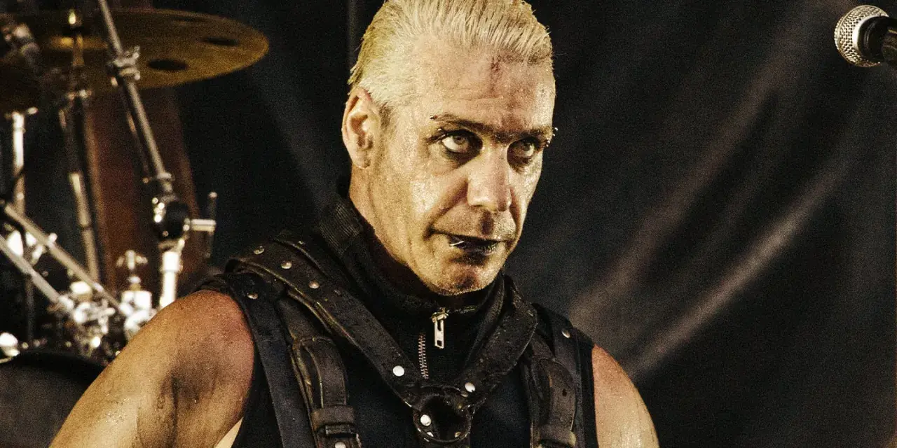 Till Lindemann młody, w skórzanym gorsecie, z mokrymi włosami i intensywnym spojrzeniem, gotowy do występu na scenie.