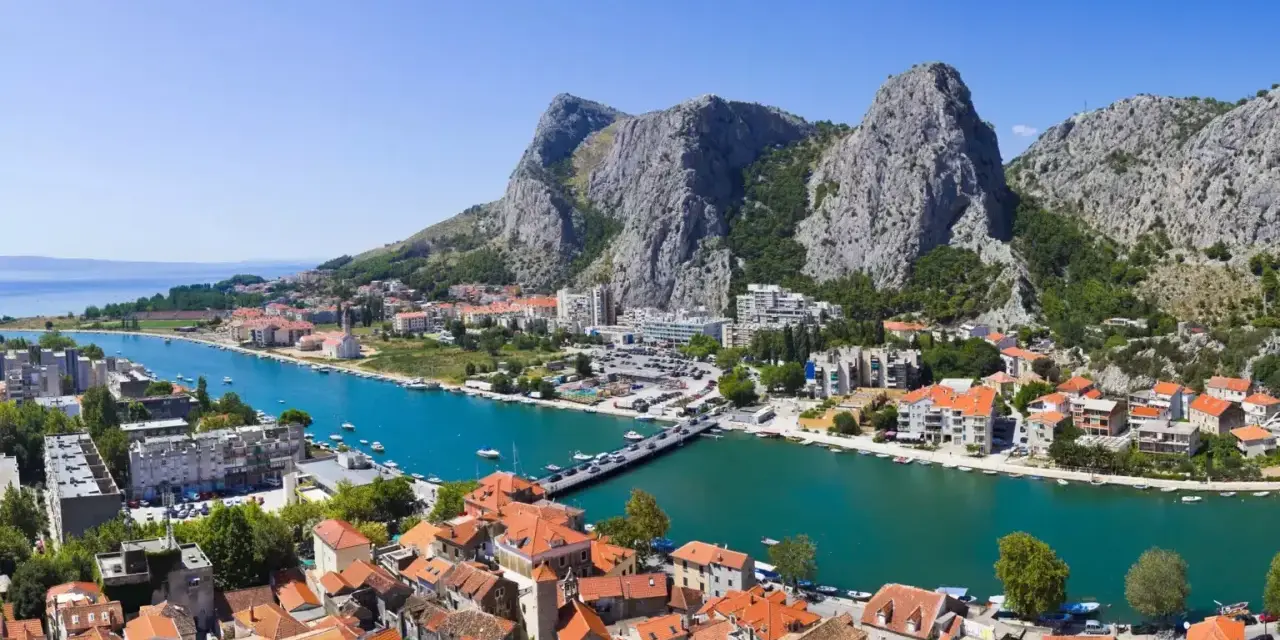 Widok na miasto Omiš w Chorwacji, gdzie rzeka Cetina wpada do morza. Piękne, turkusowe morze i góry.
