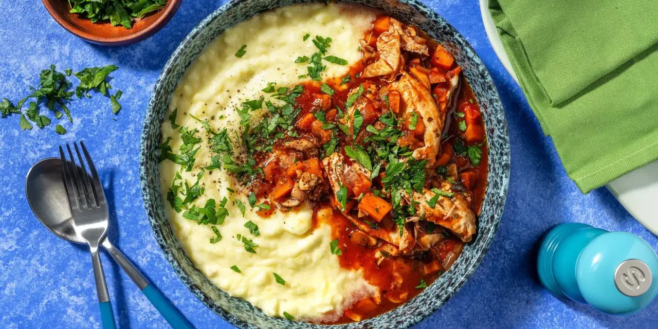 En härlig skål med krämig potatismos och kyckling i tomatsås, en smak av fransk mat. Garnerad med färsk persilja.