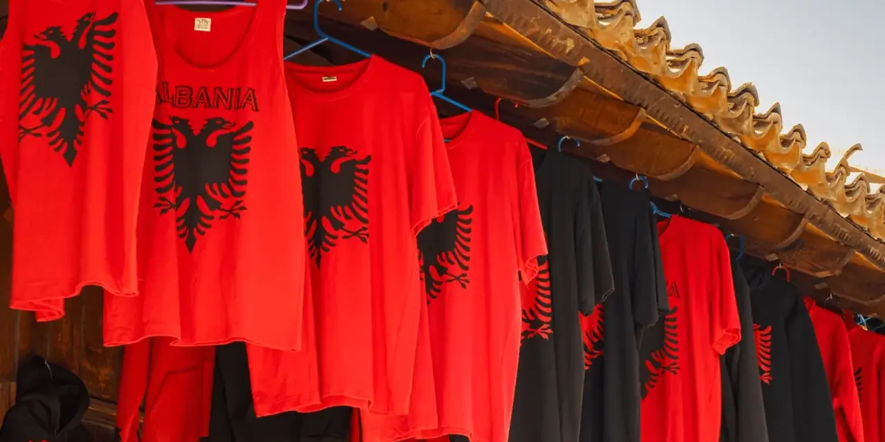 Czerwone i czarne koszulki z dwugłowym orłem, idealne pamiątki, co można przywieźć z Albanii samolotem.