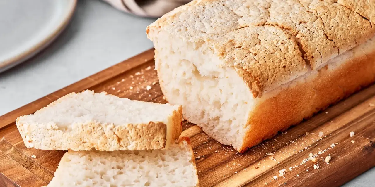 Ein Laib japanisches Reisbrot, aufgeschnitten auf einem Holzbrett. Dieses Rezept für japanisches Reisbrot ist perfekt für alle, die glutenfreies Brot lieben.