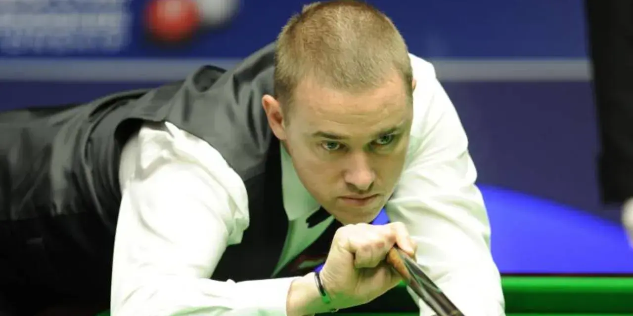 Gracz snookera w skupieniu celuje kijem do bili. Czy to on zostanie mistrzem świata w snookerze 2025?