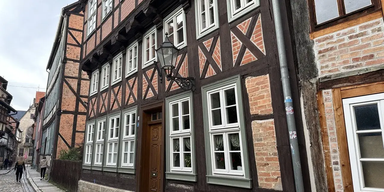 Vackra korsvirkeshus i Tyskland kantas av en kullerstensgata. De mörka träbjälkarna och tegelväggarna skapar en historisk atmosfär.