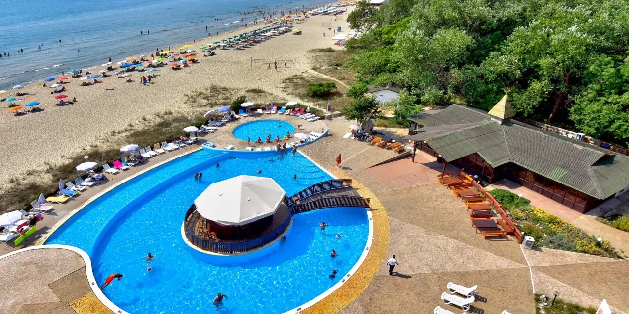 Słoneczny dzień w Albena Bułgaria. Ludzie odpoczywają na plaży i kąpią się w basenie z barem.