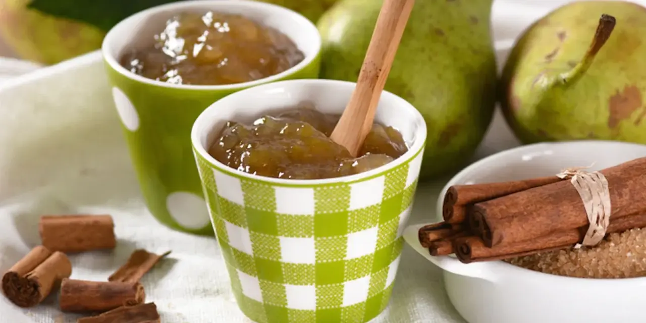 Due tazze con **marmellata di pere** fatta in casa, pere fresche, cannella e zucchero di canna.