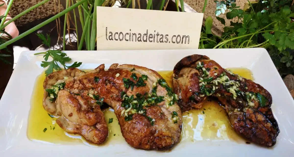 Delicioso hígado de rape a la plancha con ajo y perejil, servido en una bandeja blanca.