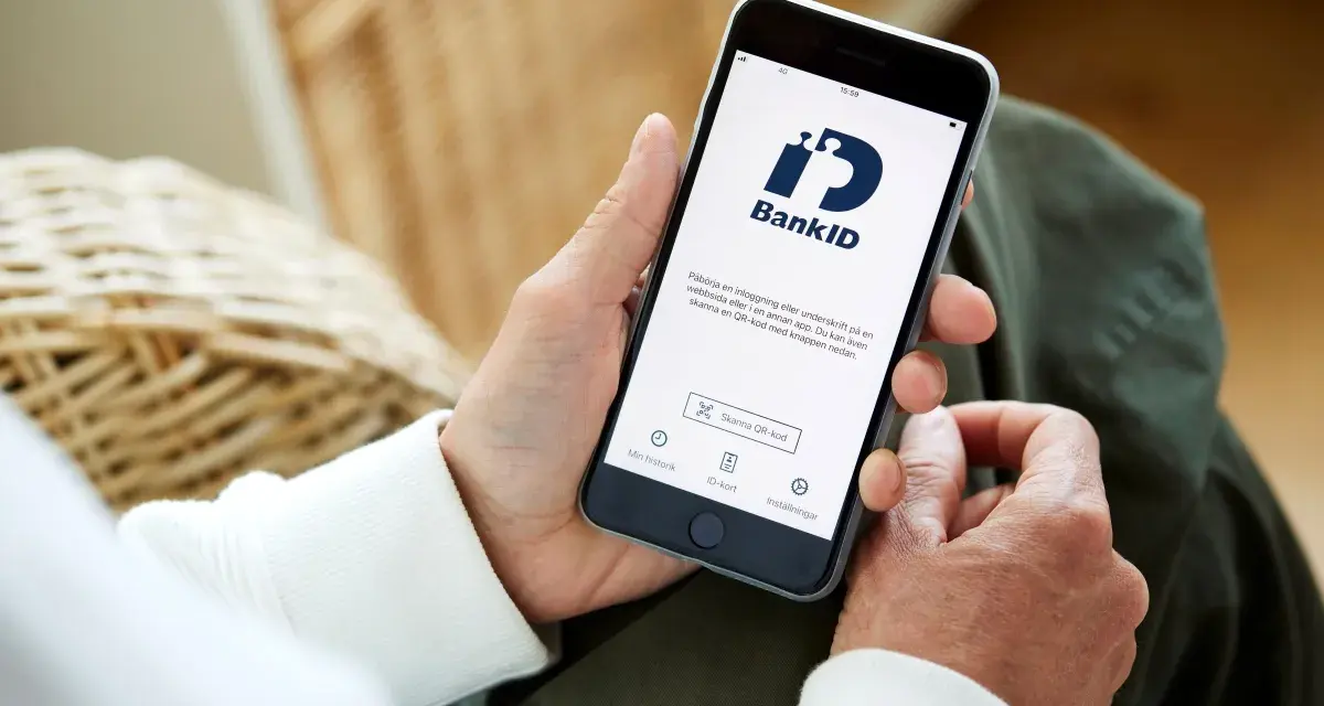 Person använder sin smartphone med BankID-appen för att logga in eller signera.