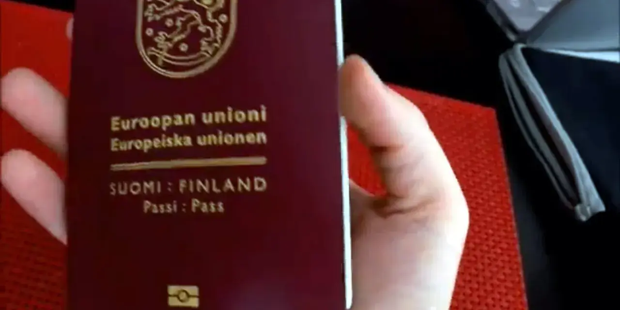 Dłoń trzyma paszport Finlandii. Czy do Finlandii trzeba mieć paszport? Tak, jeśli nie jesteś obywatelem UE/Schengen.