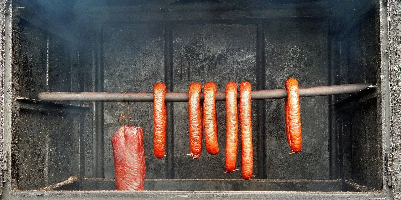 Kiełbasa wędzi się w dymie, tworząc apetyczny kolor. Idealna temperatura wędzenia kiełbasy to klucz do sukcesu.