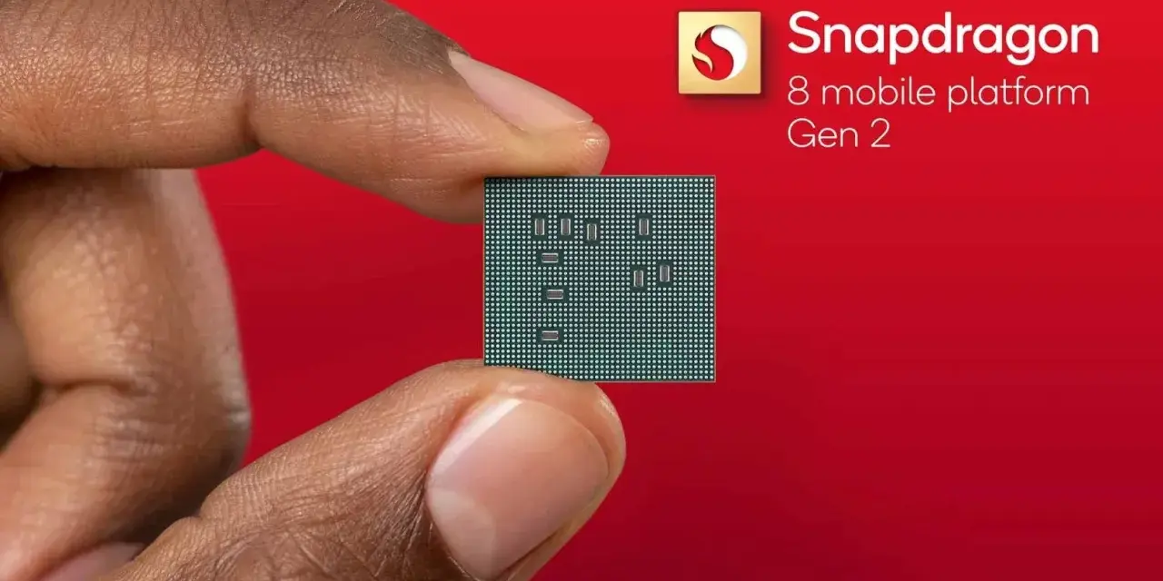 Palec i kciuk trzymają niewielki procesor. Obok widnieje logo Snapdragon 8 mobile platform Gen 2.
