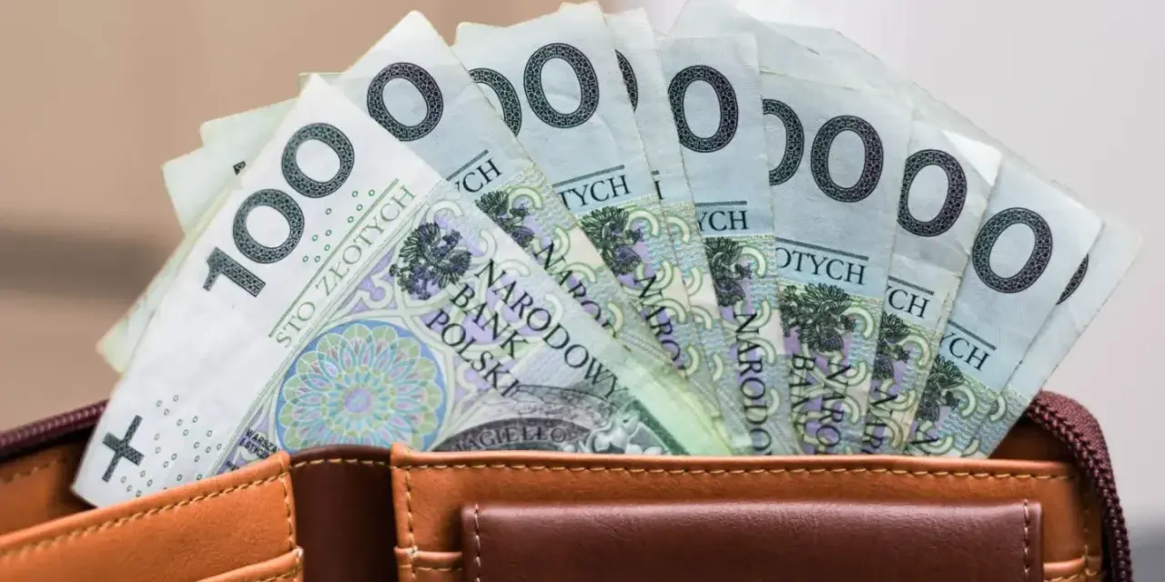 Portfel z banknotami 100 zł. Czy urlop wychowawczy jest płatny? To pytanie nurtuje wielu rodziców, a pieniądze w portfelu mogą pomóc w podjęciu decyzji.