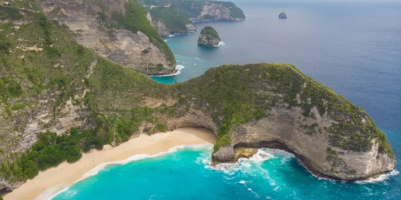 Widok z lotu ptaka na klify, piaszczystą plażę i turkusowe morze na Bali.