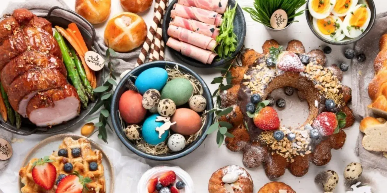 A festive Easter feast in Europe, featuring a glazed ham, colorful eggs, sweet breads, and a decorated cake.