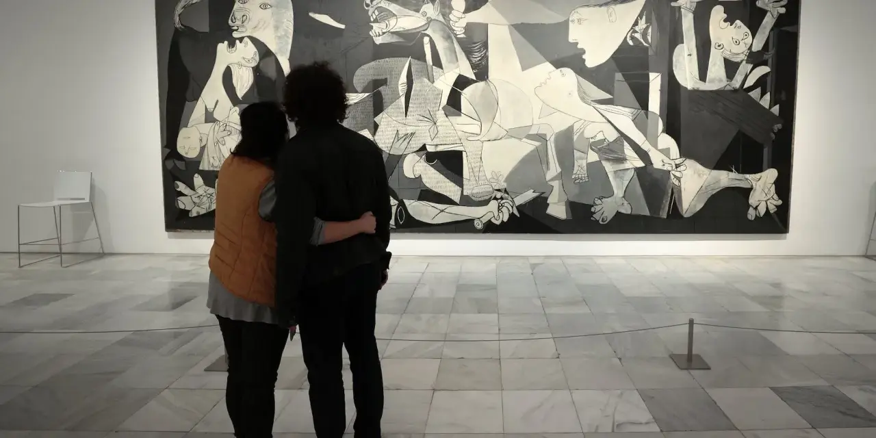 Para ogląda słynne **guernica obraz** Picassa, pełne bólu i chaosu.