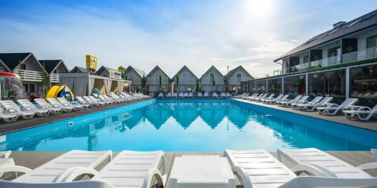 Słoneczny basen z leżakami w holiday park & resort Grzybowo. Opinie o tym miejscu są świetne!