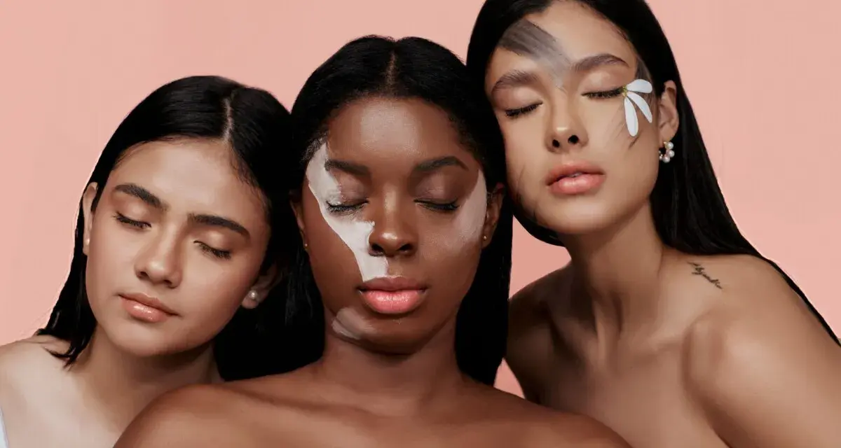 Tre donne con diverse tonalità di pelle, una con un trucco artistico sul viso, evocano la bellezza naturale e l'efficacia del palmitoyl tripeptide-1.