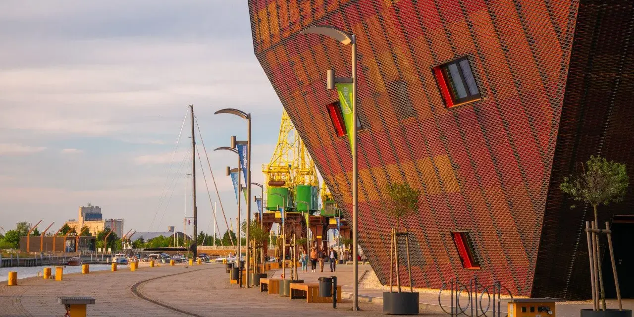Nowoczesna architektura i portowe klimaty – to właśnie co można zwiedzić w Szczecinie. Widok na nabrzeże z charakterystycznym budynkiem.