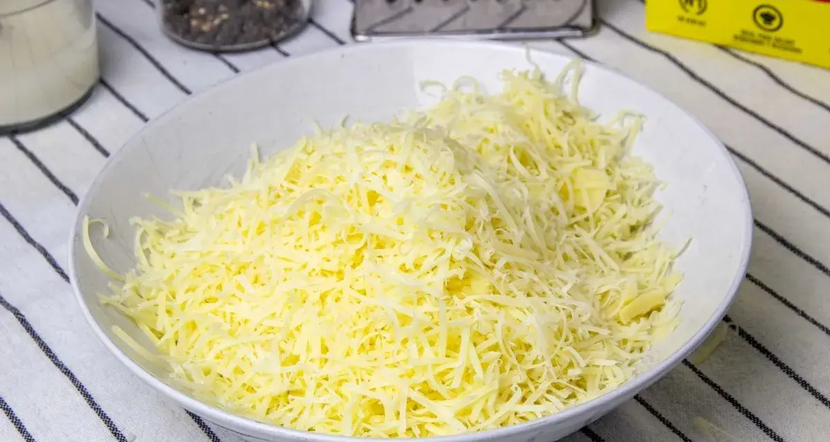 Queso rallado en un bol blanco, listo para hacer fondue.