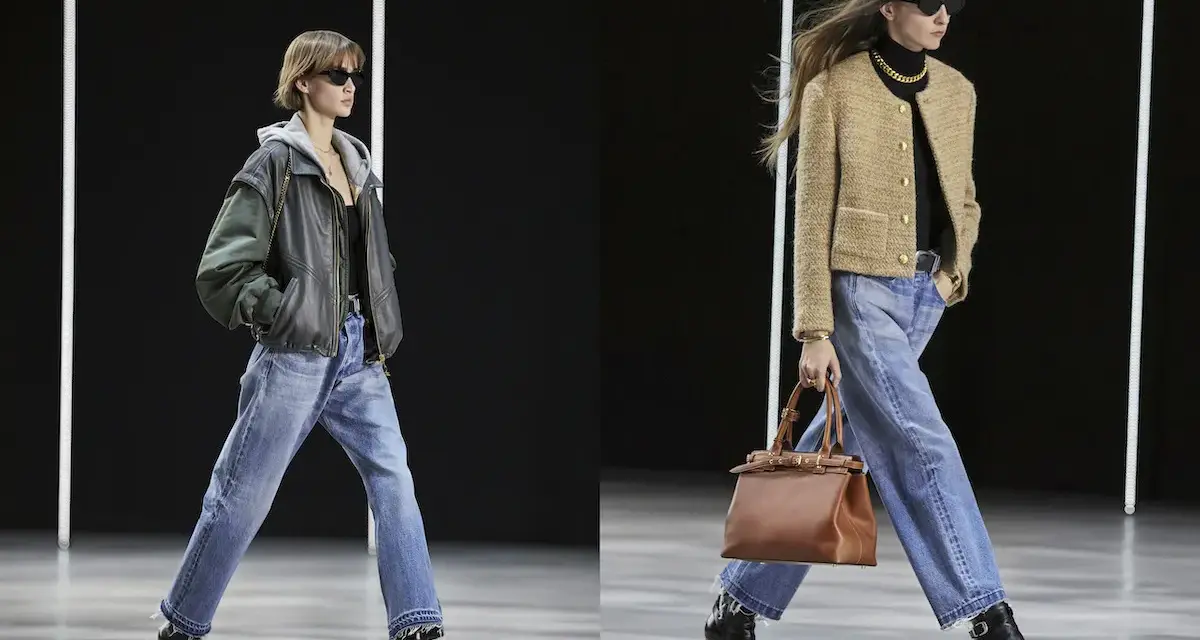 Due modelle sfilano con un **outfit jeans e stivali**. La prima indossa una giacca in pelle e cappuccio, la seconda un blazer beige.