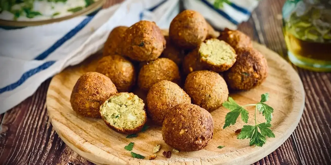 Frisch zubereitete Falafel auf einem Holzbrett, perfekt zum falafel selber machen. Ein Genuss für jeden Liebhaber der orientalischen Küche.