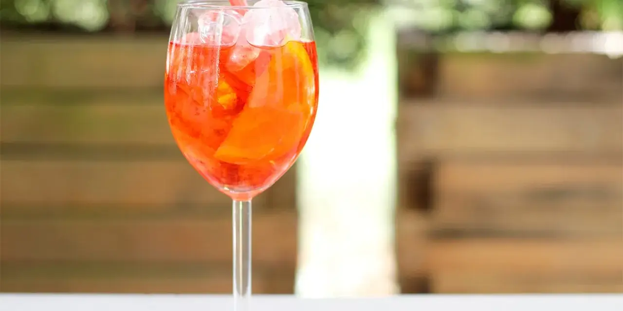 Orzeźwiający Aperol Spritz z lodem i pomarańczą, idealny na letnie popołudnie.