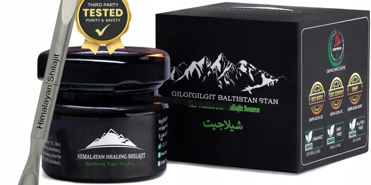Srebrna szpatułka z napisem "Himalayan Shilajit" obok czarnego słoiczka i pudełka z górami. Certyfikaty potwierdzają jakość shilajitu.