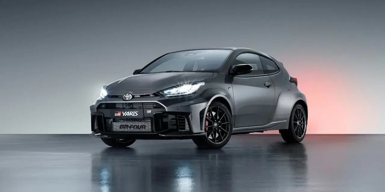Szary Toyota GR Yaris GR-FOUR z agresywnym przednim zderzakiem i czarnymi felgami, gotowy do podboju dróg.